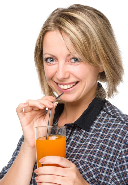 Young woman is drinking carrot juice — Stock Photo, Image