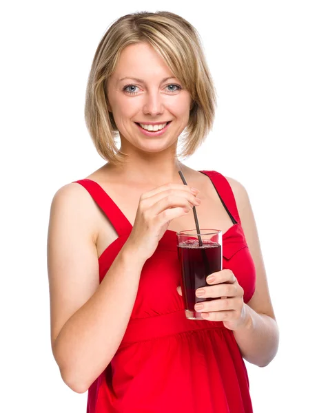 Young woman is drinking cherry juice — Stock Photo, Image