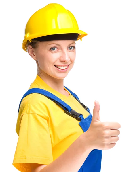 Unga byggnadsarbetare visar tummen upp skylt — Stockfoto