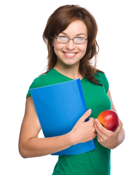 Joven estudiante chica está sosteniendo libro y manzana — Foto de Stock