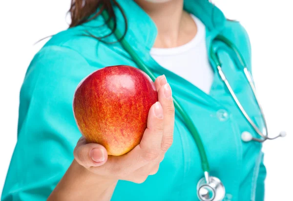 Lady doctor is holding a red apple — Stock Photo, Image