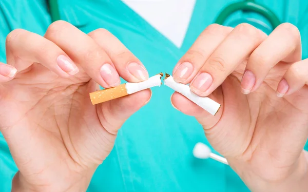 Doutor em uniforme quebra cigarro — Fotografia de Stock