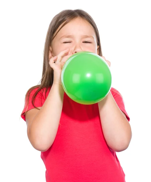 Menina está inflando balão verde — Fotografia de Stock