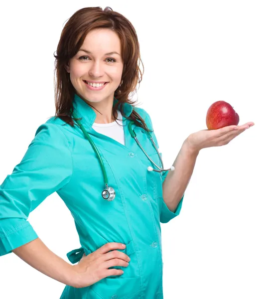 La joven doctora sostiene una manzana roja — Foto de Stock