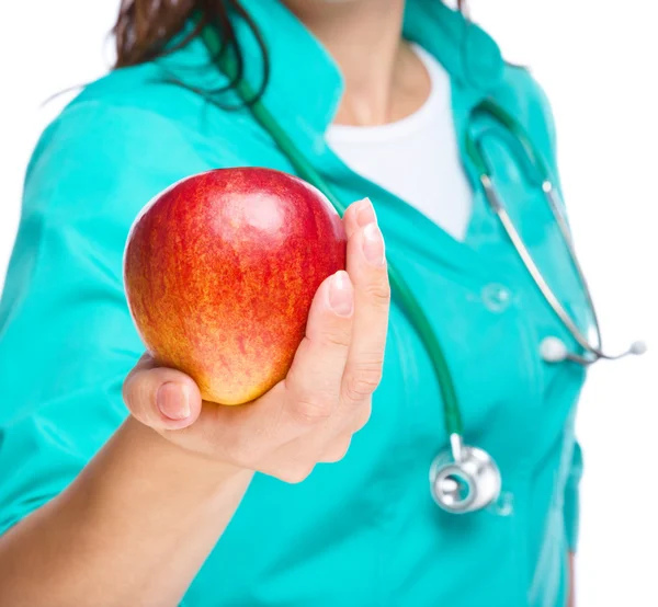 Lady doctor is holding a red apple — Stock Photo, Image