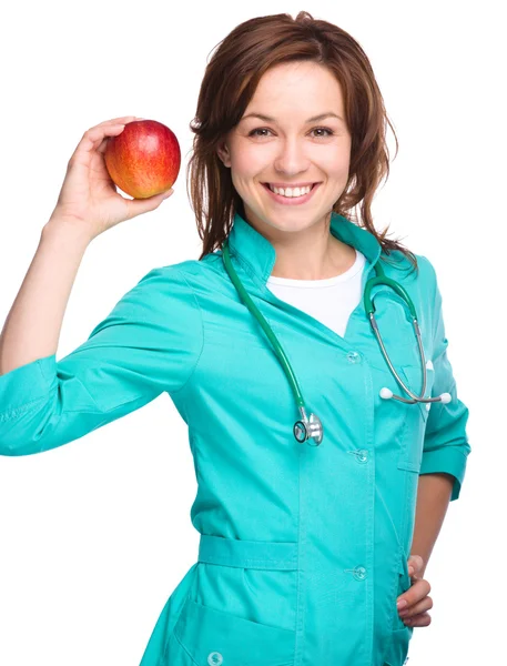 Giovane signora medico sta tenendo una mela rossa — Foto Stock