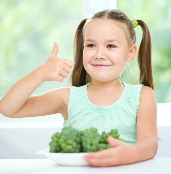 Söt liten flicka äter gröna druvor — Stockfoto