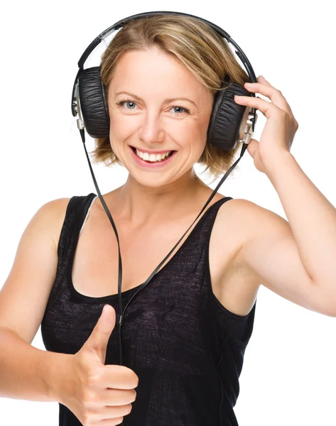 Jeune femme appréciant la musique en utilisant des écouteurs — Photo
