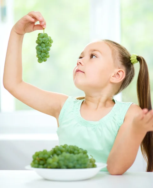 Roztomilá holčička je jíst zelené hrozny — Stock fotografie