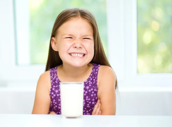 Sad little girl with a glass of milk — Stock Photo, Image