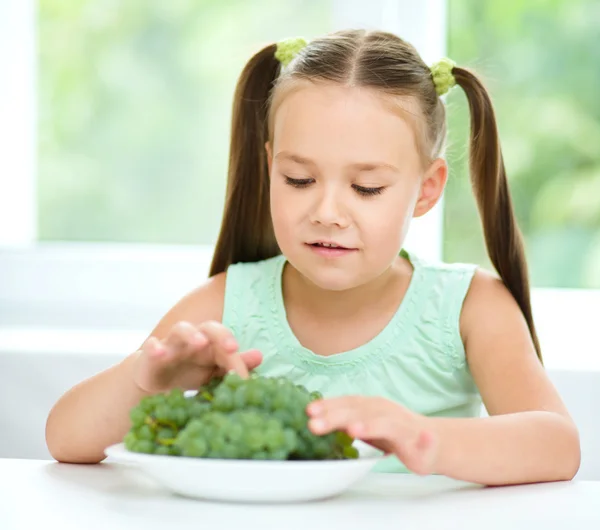 Söt liten flicka äter gröna druvor — Stockfoto