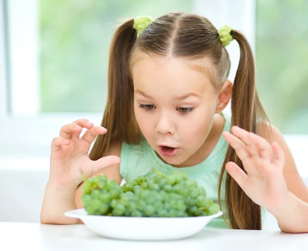 Niedliches kleines Mädchen isst grüne Trauben — Stockfoto