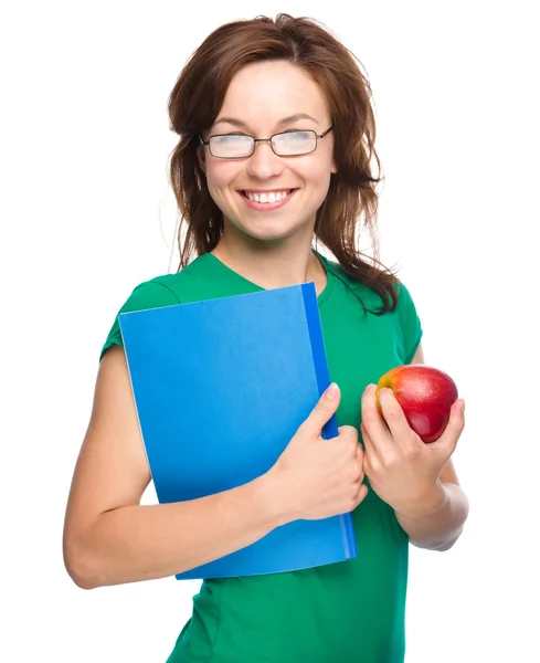 Joven estudiante chica está sosteniendo libro y manzana — Foto de Stock