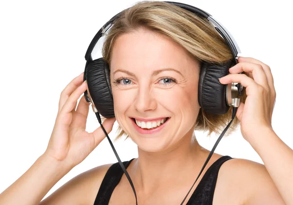 Mujer joven disfrutando de la música usando auriculares — Foto de Stock