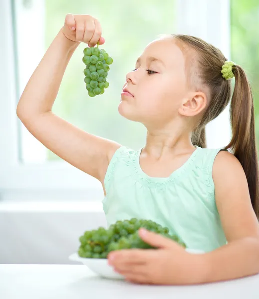 Roztomilá holčička je jíst zelené hrozny — Stock fotografie
