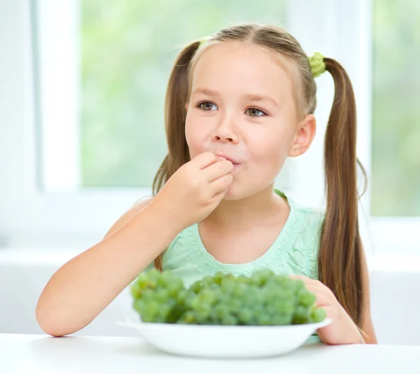 Aranyos kislány eszik zöld szőlő — Stock Fotó