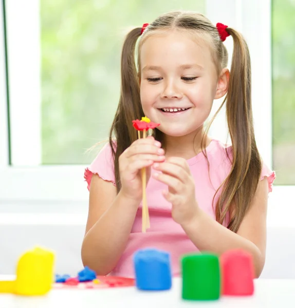 Kleines Mädchen spielt mit Knetmasse — Stockfoto