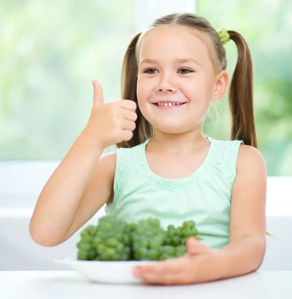 Niedliches kleines Mädchen isst grüne Trauben — Stockfoto