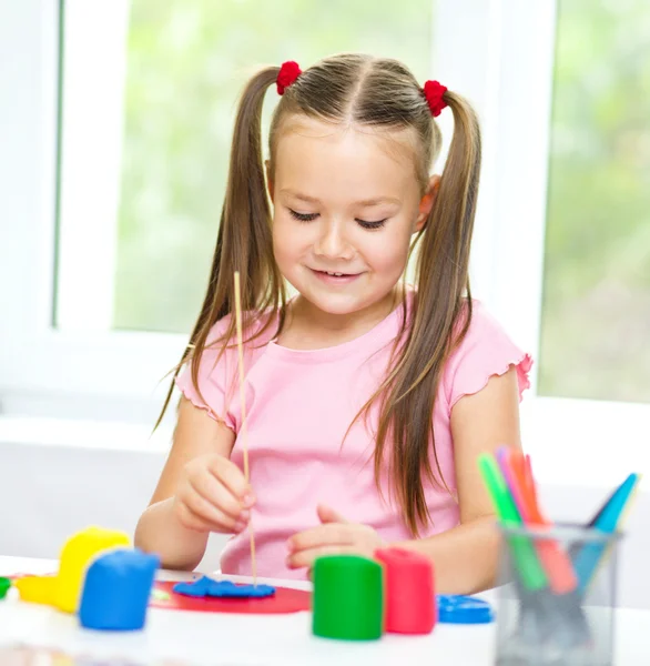 Little girl is playing with plasticine — Stock Photo, Image