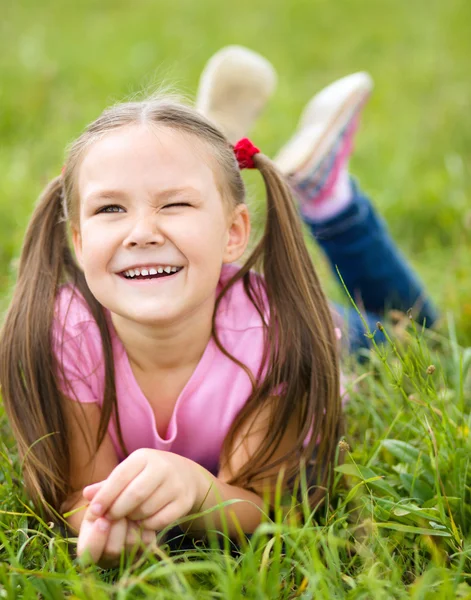 Yeşil çimenlerin üzerinde döşeme küçük bir kızın portresi — Stok fotoğraf