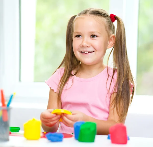 小さな女の子は粘土で遊んでいます。 — ストック写真