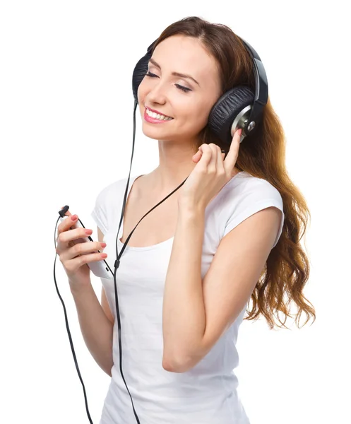Ung kvinna njuter av musik med hörlurar — Stockfoto