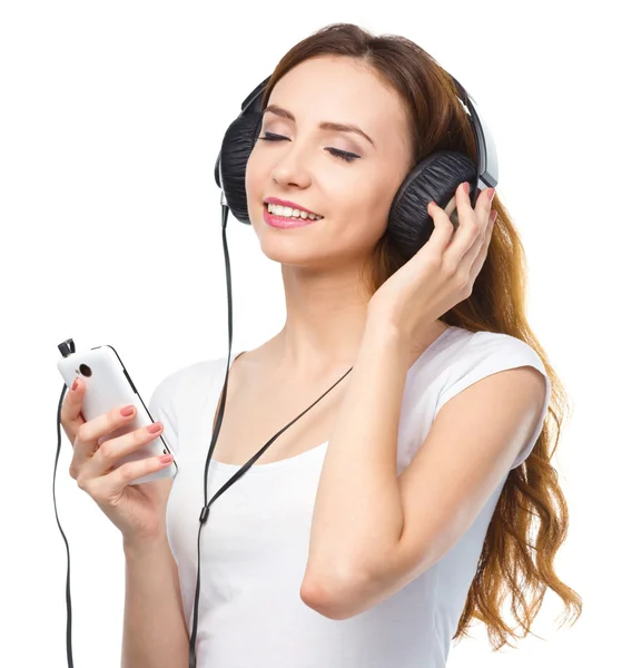 Mladá žena se těší hudby pomocí sluchátek — Stock fotografie