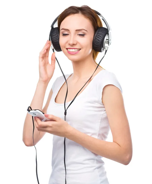 Mladá žena se těší hudby pomocí sluchátek — Stock fotografie