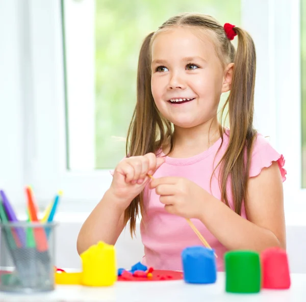 Girl is having fun while playing with plasticine — Stock Photo, Image