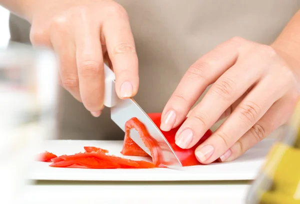 Cozinheiro está cortando pimentão — Fotografia de Stock