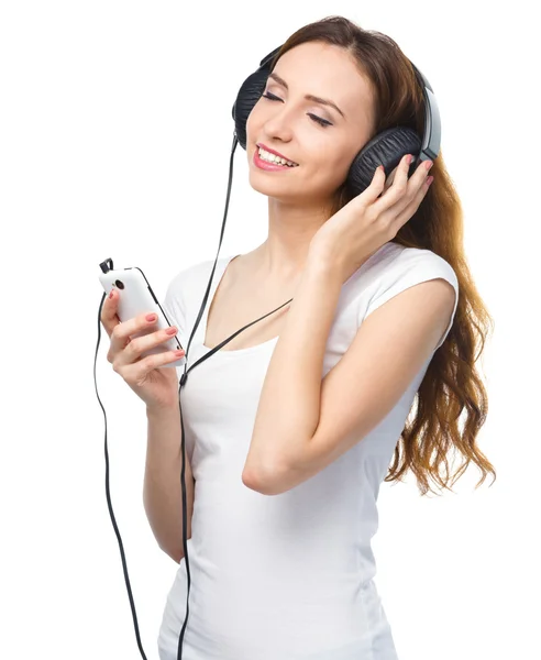 Ung kvinna njuter av musik med hörlurar — Stockfoto