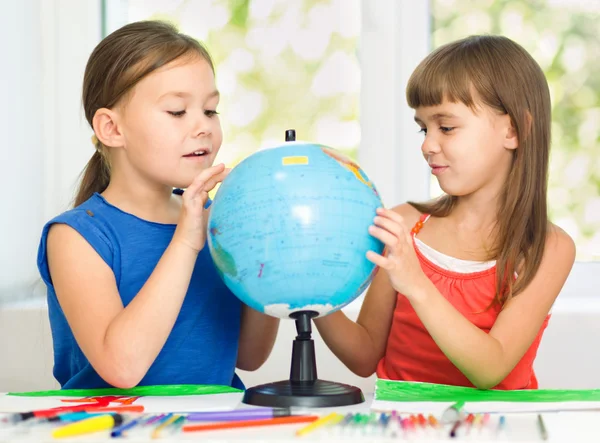 As meninas estão examinando globo — Fotografia de Stock