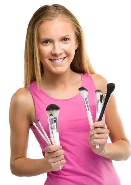 Teen girl is holding makeup brushes — Stock Photo, Image