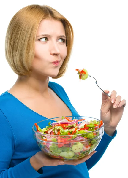 Mladá atraktivní žena je jíst salát pomocí vidlice — Stock fotografie