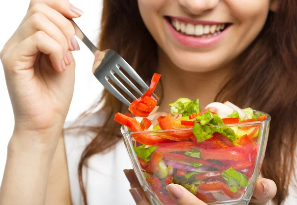 Jeune femme attirante mange salade à l'aide de la fourche若い魅力的な女性はフォークを使用してサラダを食べています。 — ストック写真