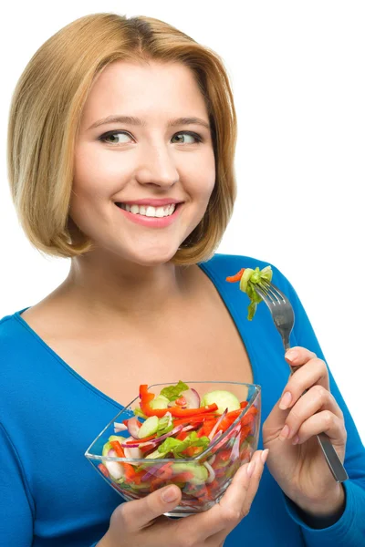 Giovane donna attraente sta mangiando insalata utilizzando forchetta — Foto Stock