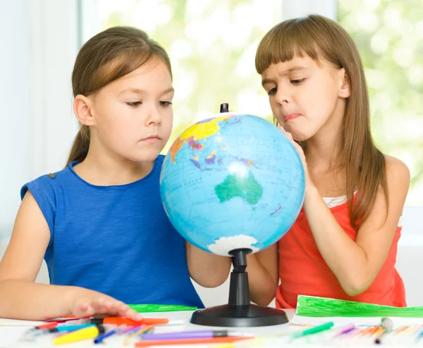 As meninas estão examinando globo — Fotografia de Stock