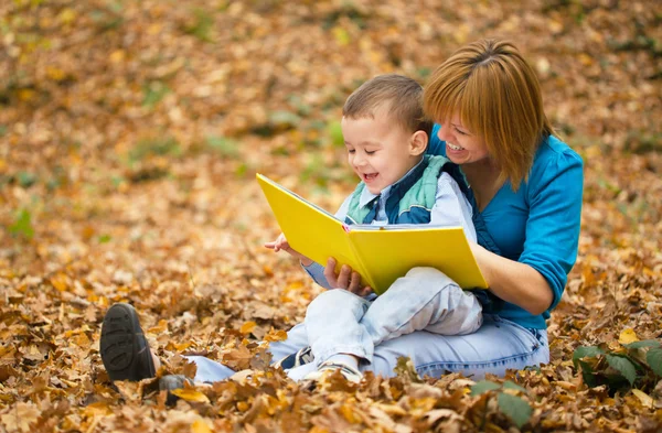 Mãe está lendo livro com seu filho — Fotografia de Stock