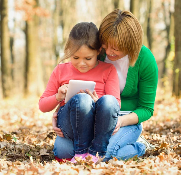 Mãe está lendo do tablet com sua filha — Fotografia de Stock