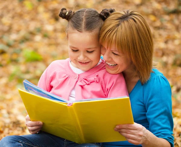 Mamma läser bok med dottern — Stockfoto