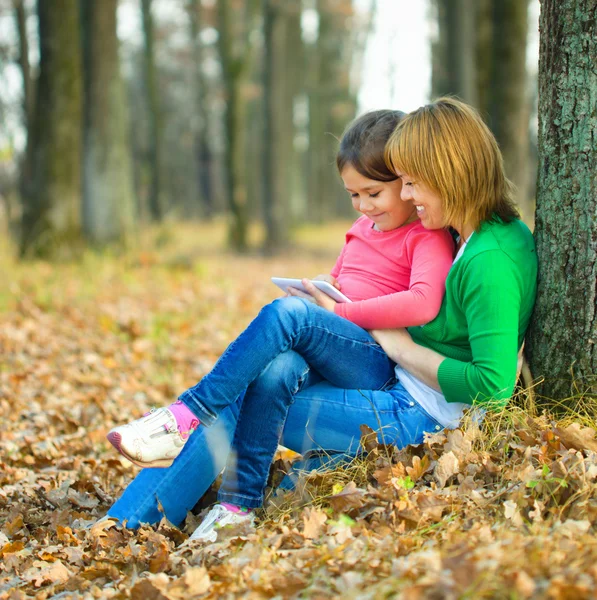 Anne kızıyla birlikte tablet okuyor — Stok fotoğraf