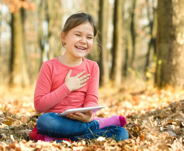 Den lille jenta leser en bok utendørs – stockfoto