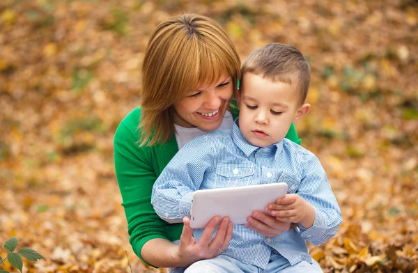 Mamma läser från tablett med sin son — Stockfoto