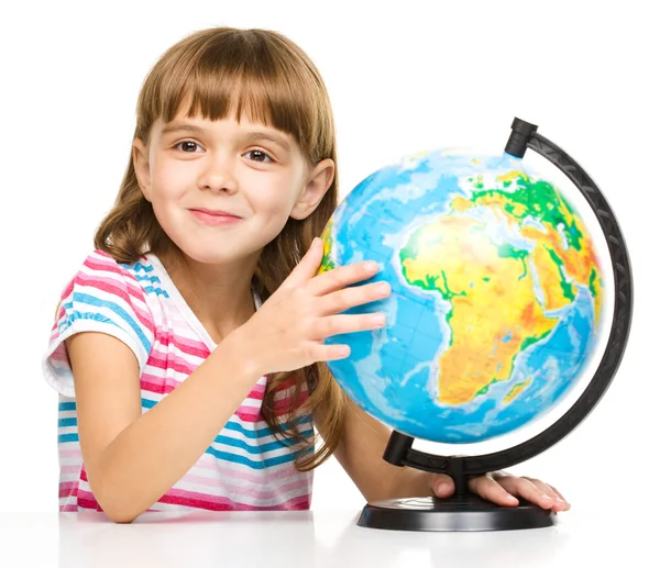 Little girl is examining globe — Stock Photo, Image