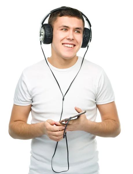 Jonge man genieten van muziek met behulp van de hoofdtelefoon — Stockfoto