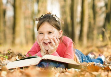 küçük kız açık havada bir kitap okuma