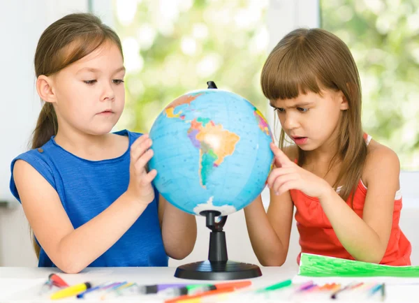 As meninas estão examinando globo — Fotografia de Stock