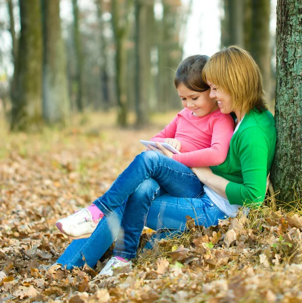 Mãe e sua filha está brincando com tablet — Fotografia de Stock