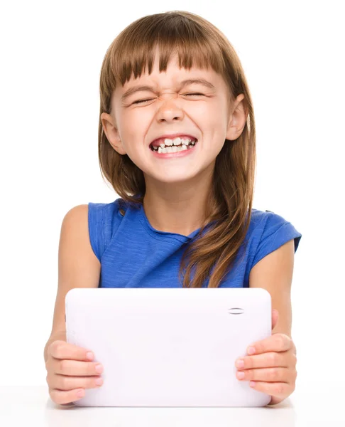 Jovem menina alegre está usando tablet — Fotografia de Stock