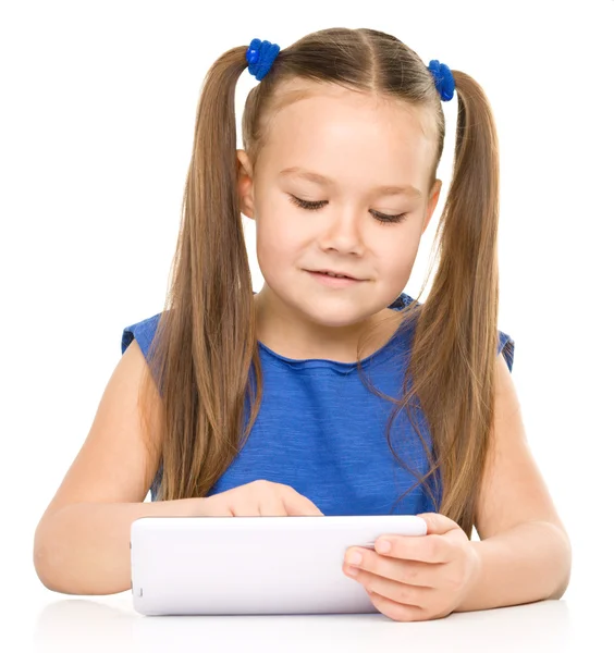 Jovem menina alegre está usando tablet — Fotografia de Stock